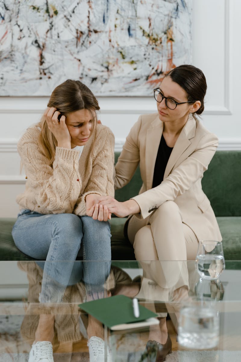 A comforting moment between two women in an indoor setting, showcasing empathy and support.
